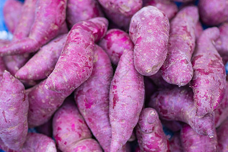 一堆新鲜的紫色山药在市场上出售有机水果有益健康食物和图片