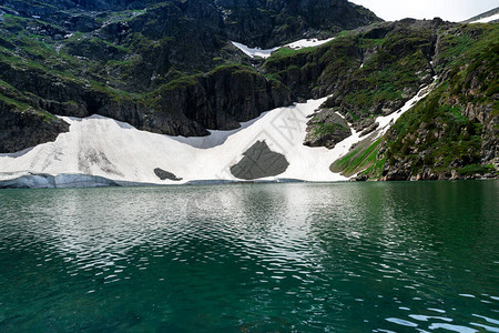 高山湖泊与绿松石水特写山的背景山中的大冰川为高地湖泊提供图片