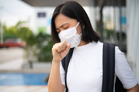 身着防护面罩戴防毒和污染面具咳嗽和站在百货商店的亚洲妇女图片