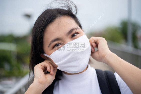 亚洲女快乐地微笑着戴防护面罩预防和污染图片