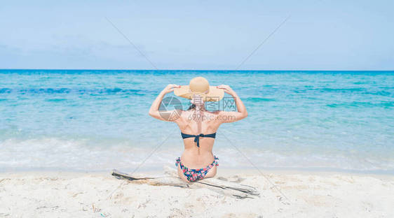 快乐的女人享受海滩放松快乐在夏天由热带蓝色的水意大利撒丁岛丰塔纳马雷海滩上戴着太阳帽旅行的漂亮快图片