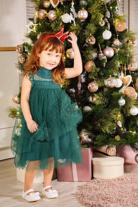 穿着深绿色礼服的小女孩和公主王冠在圣诞图片