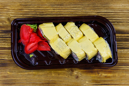 寿司奶酪卷在木桌上的塑料盒里顶视图在塑料容器中外卖或运图片