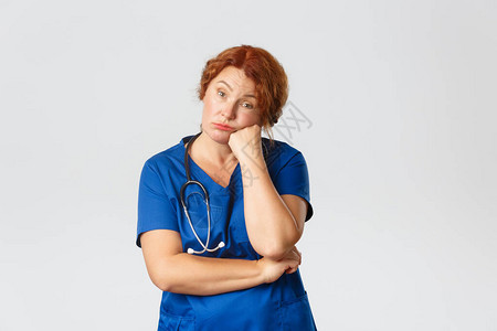 无聊而疲惫的中年女养老院护士诊所的医务人员或穿着工作服的医生图片