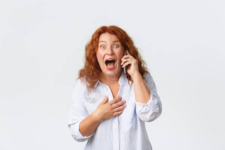 快乐微笑的红发女人通过手机发现了惊人的消息图片