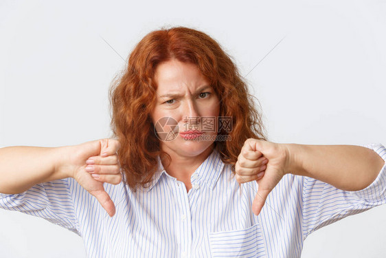失望和心烦意乱皱眉的中年红发女人看起来很烦恼和不开心的特写镜头图片