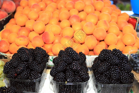 市场上的大黑莓和杏子水果图片