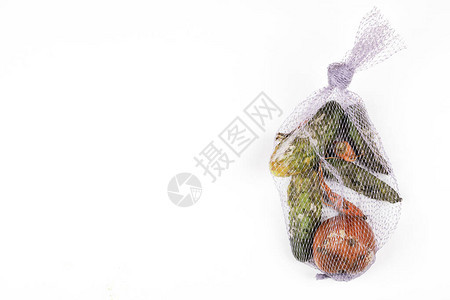 腐烂苹果黄瓜白背景的网状袋中的胡萝卜全球饥饿问题过度消费概念顶端图片