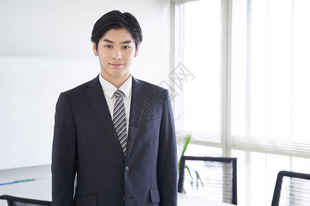 一名日本男商人站在会议室里坐在图片