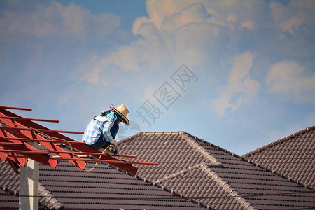 建筑焊工在有云天的建筑工地安装房屋顶钢架结构图片