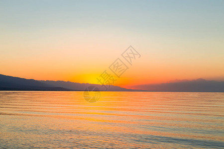 海上太阳的黎明山后初升的太阳背景图片