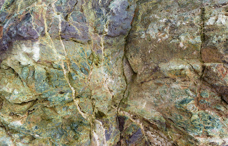 绿色碧玉或辉长岩辉绿岩的石头质地旧巨石美丽的灰绿色背景有裂缝和凿痕的石头用于景观美化的巨石图片