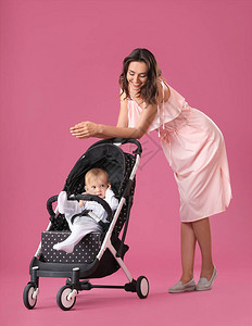 女人和她可爱的婴儿在婴儿车里图片