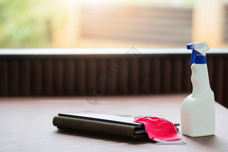 餐桌上的一瓶清洁剂和一个医用口罩图片