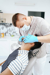 在医生检查牙齿时坐在牙医座椅上微笑的图片