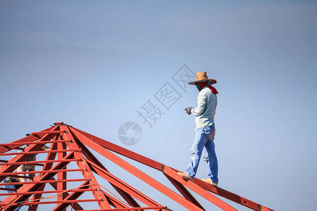 建筑焊工在有云天的建筑工地安装房屋顶钢架结构图片