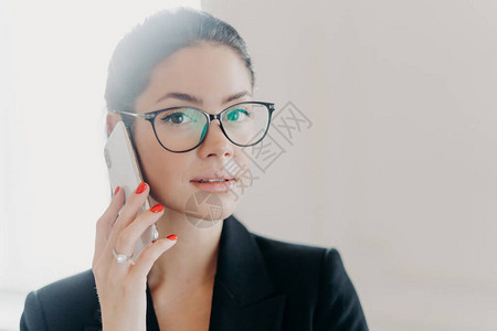 黑发美女在手机上讲话的特写镜头图片