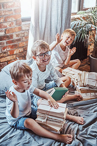 一个家庭的儿童在轻屋子里用砖墙休息和玩耍图片