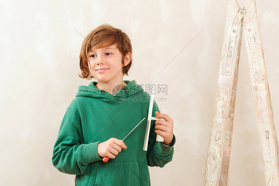 可爱的男孩用抹刀工作家居装修可爱的儿子帮助父母修理房间带工具的孩子图片