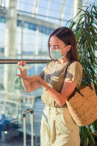 戴面罩的旅游女孩在国际机场预防用于和疾病防护的公背景图片