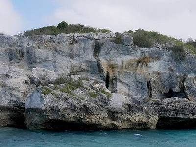 巴哈马埃克苏马珊瑚礁湛蓝海水中雷球石窟的岩石峭壁特写图片