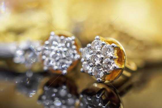 黑色背景反射的豪华黄金珠宝钻石耳环图片