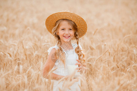 穿着草帽在小麦田里喝牛奶的金图片