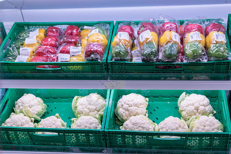 蔬菜商店货架上待售的辣椒和花椰菜图片