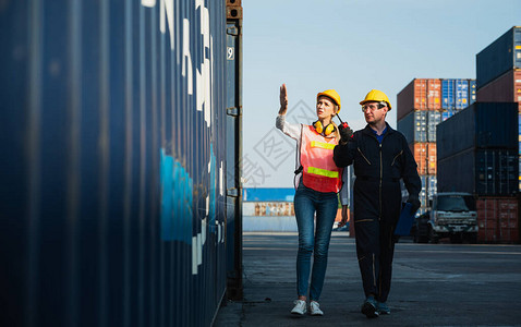 慧港国际公寓两名工头男女工人在集装箱货港检查装载集装箱码头男女员工业务物流进背景