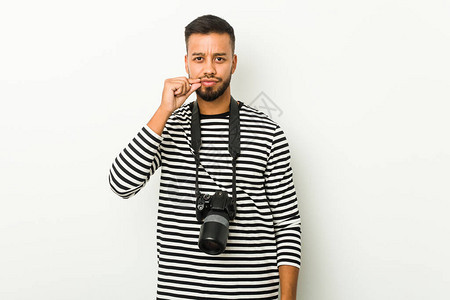 年轻的南西洋摄影师用手指在嘴唇图片