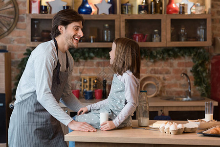 可爱的小女孩在厨房里和爸一起做饭图片