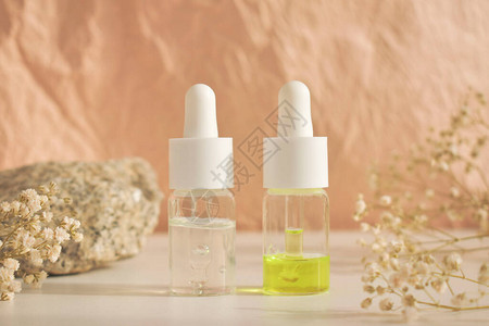自然背景的白色桌子上的玻璃瓶中装着几瓶精油图片