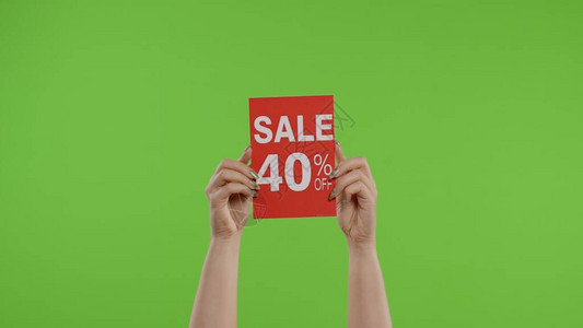 出售40折扣广告题字在绿色屏幕上的女人手中的纸上假日折扣图片