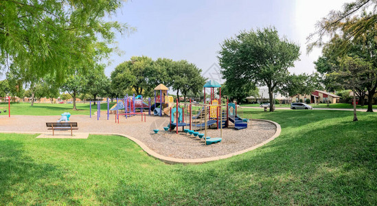 美国得克萨斯州理查森住宅区附近的全景多彩博的游乐场社区设施被大橡树背景图片