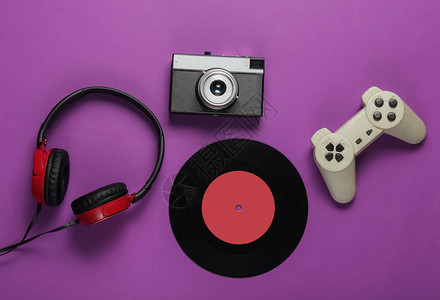 紫色背景上的流行文化媒体属游戏手柄胶卷相机黑胶唱片耳机80图片