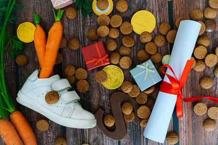 荷兰节日Sinterklaas与儿童鞋背景圣诞老人马的胡萝卜礼品传统甜点佩珀诺特和巧克力信Schoentjezetten概念平图片