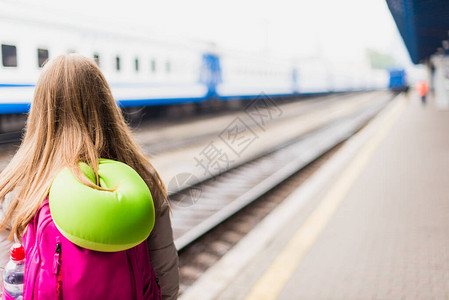女孩在等火车有背包和绿色图片