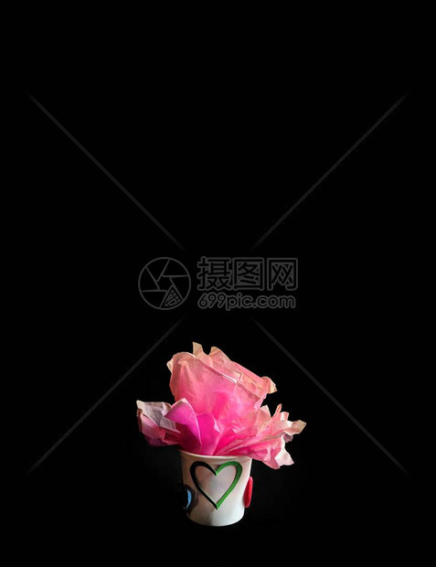 塑料杯有纸玫瑰和黑色背景的心脏图片