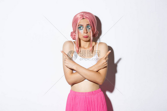 穿着粉红色假发和圣礼服摇摆不稳站立在白背景上指着手指的侧面图片