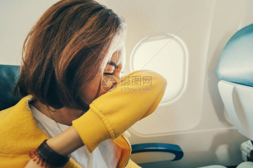 女飞机乘客打喷嚏到她的肘部航空运输过程中出现冠状和covid19感图片