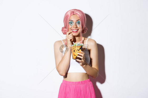 戴着粉红色假发和亮妆的快乐迷人女孩的形象去捣蛋图片