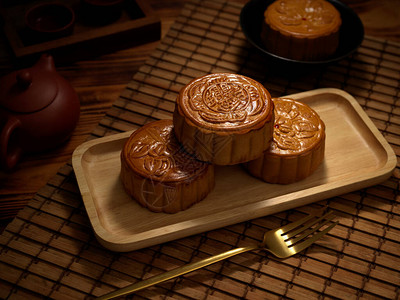 月饼代表我心用叉子和茶具在木板上近距离观察传统月饼月饼上的汉字用英文代表背景