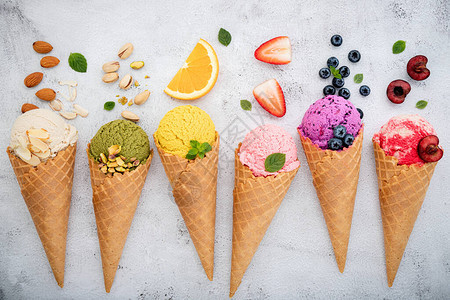各种冰淇淋口味的甜锥蓝莓松果杏仁橘子和樱桃图片