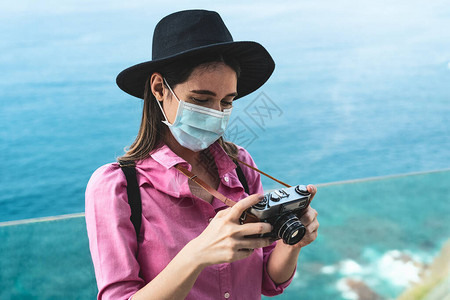 年轻的旅行女用老式相机拍照图片