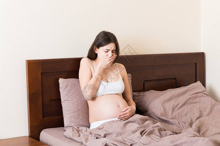 妊娠症状预期中毒年轻呕吐妇女坐在床上为人父母的观念图片