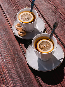 两杯白茶和柠檬放在红木桌上背景图片