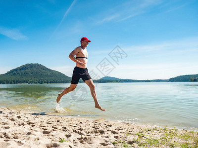 赛跑者在海滩的水中奔跑图片