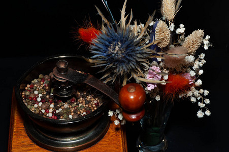一张胡椒磨粉机和一束干鲜花合照紧贴图片