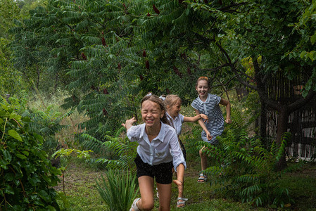 3名女学生在雨中女孩在温暖的天气下奔跑图片