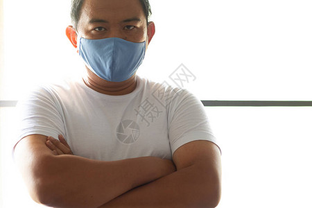 亚洲男子戴卫生口罩以预防感染空气传播的呼吸道疾病图片